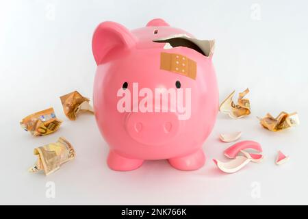 Simbolo di una banca piggy per l'inflazione, l'economia e la crisi. Rosa su sfondo bianco Foto Stock