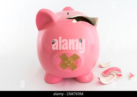 Simbolo di una banca piggy per l'inflazione, l'economia e la crisi. Rosa su sfondo bianco Foto Stock