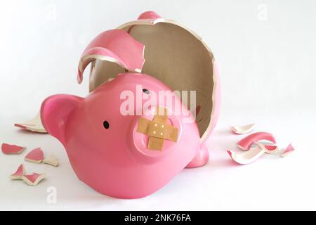 Simbolo di una banca piggy per l'inflazione, l'economia e la crisi. Rosa su sfondo bianco Foto Stock