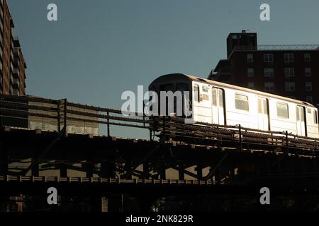 Bronx New York, treno sopraelevato della metropolitana 6 che riflette la luce del sole della mattina presto Foto Stock