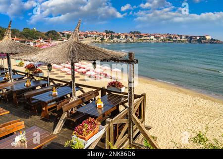 Paesaggio sul mare - vista del caffè e della spiaggia di sabbia con ombrelloni e lettini nella città di Sozopol sulla costa del Mar Nero in Bulgaria Foto Stock