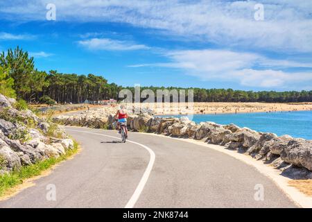 Paesaggio costiero - vista della costa atlantica con un ciclista donna vicino alla città di la Palmyre, nel sud-ovest della Francia Foto Stock