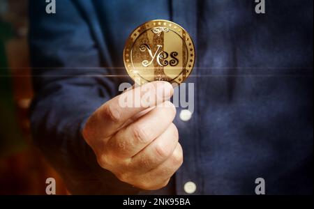 Sì o No scelta casuale di decisione e scommettere moneta d'oro in mano concetto astratto Foto Stock