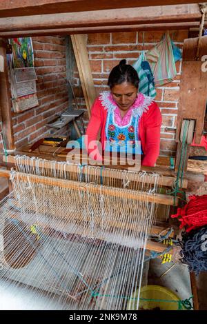 Una donna indigena Zapotec tesse un tappeto di lana su un telaio a pedale in legno a San Miguel del Valle, Oaxaca, Messico. Foto Stock