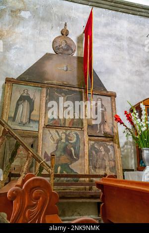 Un'antica pala d'altare in legno con dipinti nella Chiesa di San Miguel Arcangelo a San Miguel, Oaxaca, Messico. Foto Stock