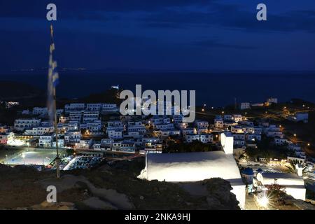 Vista panoramica del pittoresco villaggio illuminato di iOS Greece dopo il tramonto Foto Stock