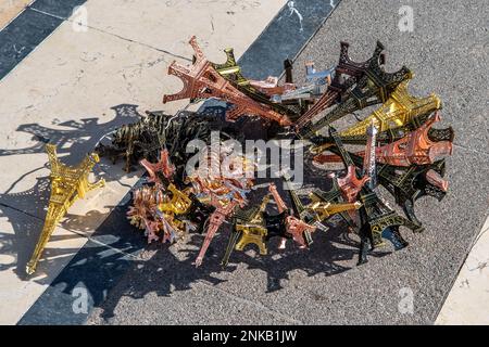 Pila con piccole sculture della Torre Eiffel in mostra da Un venditore di strada a Parigi Foto Stock
