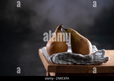 Due conferenze, Pere d'autunno e d'inverno su tela da cucina e tavolo di legno Foto Stock