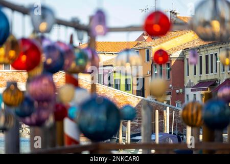 L'arte del vetro è sospesa nei vicoli di fronte a case colorate, l'isola di Murano, Venezia, Italia Foto Stock