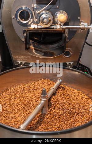 Il caffè arrosto viene versato dal tamburo di tostatura nel bollitore, nel processo di tostatura del caffè, nella macchina per la tostatura del caffè, nel Kaffeeroesterei Maassen Foto Stock