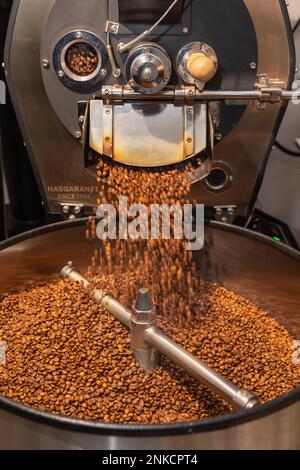 Il caffè arrosto viene versato dal tamburo di tostatura nel bollitore, nel processo di tostatura del caffè, nella macchina per la tostatura del caffè, nel Kaffeeroesterei Maassen Foto Stock