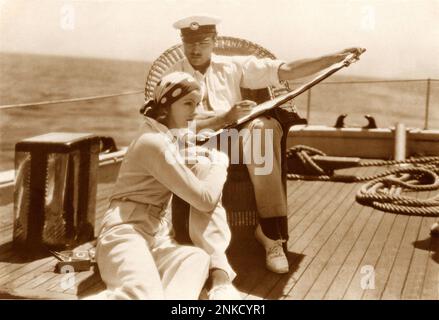 1929 , USA : l'attrice GRETA GARBO e NILS ASTHER nel SINGOLO STANDARD ( Donna che ama ) di John S. Robertson , da un romanzo di Adela Rogers St. John - MGM - FILM MUTO - CINEMA MUTO - ritratto - ritratto - cappello - cappello - foulard - yacht ---- Archivio GBB Foto Stock