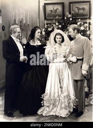 1939 , USA : The movie actress VIVIEN LEIGH ( 1913 - 1967 ) , RAND BROOKS , THOMAS MITCHELL e BARBARA o'NEIL in GONE WITH THE WIND ( Via col vento ) Di Victor Fleming - CINEMA - FILM - volanti - fiori - fiori - abito bianco - abito bianco - matrimonio - matrimonio - sposi - marito e mogli - moglie e marito - cerimonia di nozze - abito da sposa - abito nuziale - sposa - velo - Velo - uniformi militare divisa - uniforme militare - spada - spada - guanti bianchi - guanti ---- Archivio GBB Foto Stock