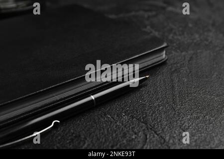 Notebook e penna su sfondo scuro, primo piano. Celebrazione della Giornata Mondiale della Poesia Foto Stock