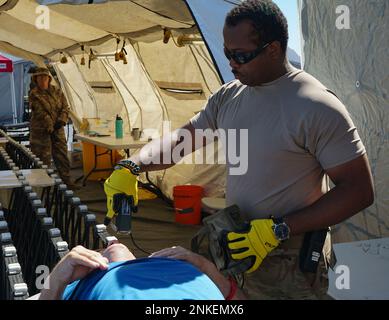 Un soldato della FEMA Region III Homeland Response Force, Pennsylvania National Guard, controlla uno scenario di esercizio ferito civile non ambulatoriale per materiali pericolosi durante l’evento collettivo di formazione del HRF il 13 agosto 2022 a Fort Indiantown Gap, Pa. Foto Stock