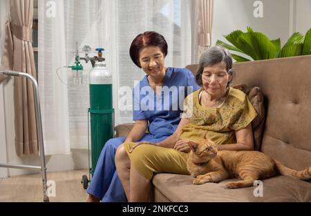 Donna anziana che indossa la cannula nasale dell'ossigeno a casa. Foto Stock