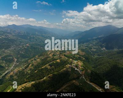 Drone aereo di piantagioni agricole e risaie a terrazze su colline in una zona montagnosa. Filippine, Luzon. Foto Stock