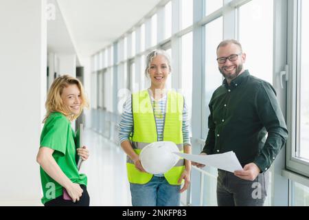 Ritratto di un uomo d'affari sorridente con dipendente e ingegnere in ufficio Foto Stock