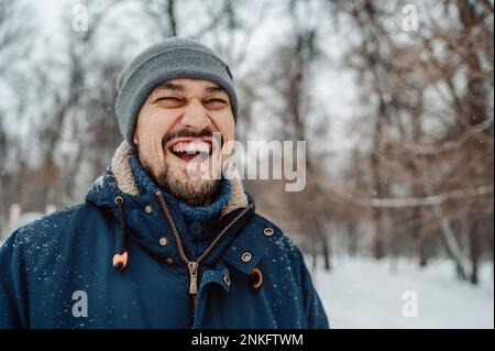 Uomo felice che si diverte nella neve Foto Stock