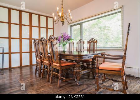 Sala da pranzo con 14th ° secolo antico tavolo in legno e sedie a griglia sul retro alto all'interno di una casa contemporanea. Foto Stock