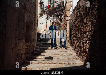 Felice uomo anziano che cammina con il figlio sulla scala Foto Stock