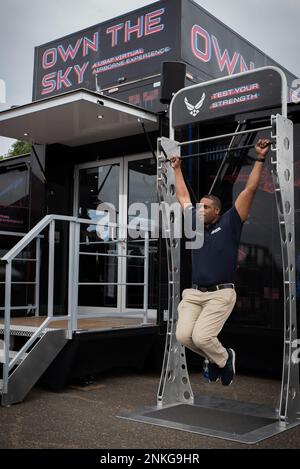 Master Sergente Efrem Swoope, reclutamento ufficio di volo capo per l'Ala Airlift 179th, parla della sua esperienza di lavoro nella Guardia Nazionale aerea mentre si esegue il test di forza in una tenda di reclutamento della Guardia Nazionale aria al Props and Pistons Festival ad Akron, Ohio il 14 agosto 2022. MSgt Swoope ritiene che il più grande vantaggio di lavorare nella Guardia Nazionale aerea sia la cultura creata dai nostri membri, mentre si prendono cura di eachother e della comunità locale. Foto Stock