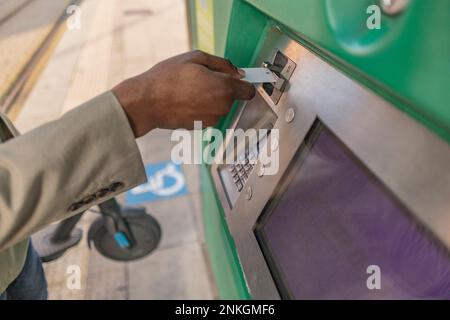 Mano dell'uomo d'affari che inserisce la carta nella macchina ATM Foto Stock