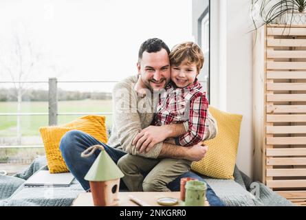 Felice padre e figlio guardando la casa modello in casa Foto Stock