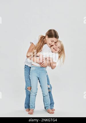 Sorelle felici che si divertono su sfondo bianco Foto Stock