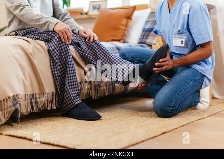 Fisioterapista che esamina la caviglia dell'uomo durante la sessione di terapia fisica Foto Stock