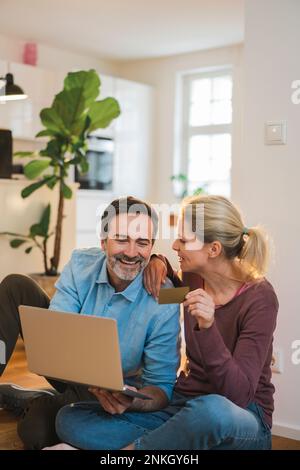 Felice coppia godendo fare lo shopping in linea nel paese Foto Stock