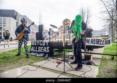 Delft, Paesi Bassi, 22/02/2023, Ocean ribellona la band heavy metal 'Polymetallic nodule' mentre si usa una barca come palco. Sono state cantate canzoni che denunciavano la società di ingegneria con testi critici per l'industria mineraria oceanica e per i danni ambientali causati dalle miniere di acque profonde. Gli impiegati di 'Allseas Engineering' hanno ricevuto un concerto improvvisato dalla band heavy metal 'Polymetallic nodule' degli Ocean Rebellions mentre utilizzava una barca come palco. Sono state cantate canzoni che denunciavano la società di ingegneria con testi critici per l'industria mineraria oceanica e per i danni ambientali causati dal minino d'altura Foto Stock