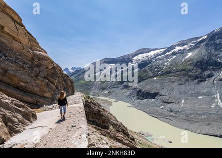 Austria, Carinzia, escursionista femminile su Gamsgrubenweg con lago Sandersee sullo sfondo Foto Stock