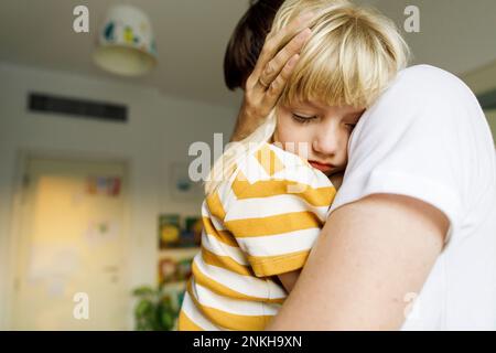 Figlia che dorme in braccio del padre a casa Foto Stock