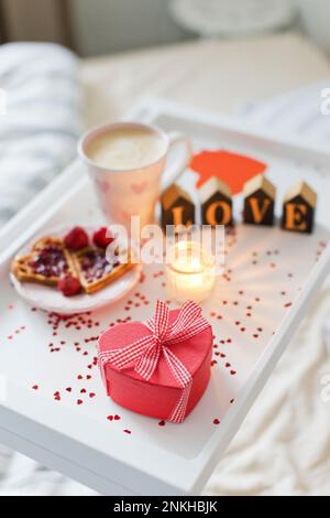 Confezione regalo a forma di cuore con colazione su vassoio Foto Stock