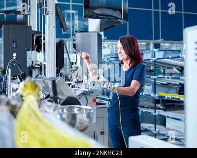 Ingegnere sorridente che lavora con macchine dell'industria Foto Stock