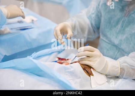 Dottore con strumenti che fanno chirurgia oculare su paziente in ospedale Foto Stock