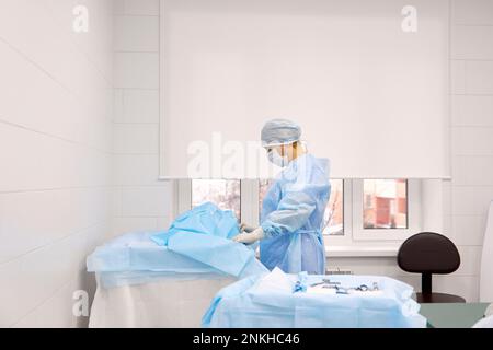 Infermiere preparazione abito in sala operatoria in ospedale Foto Stock