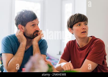Coppia matura preoccupata seduta insieme a casa Foto Stock