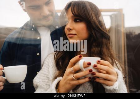 Coppia che tiene le tazze del caffè nella tenda della cupola Foto Stock