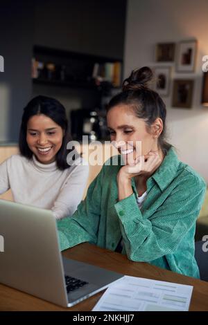 Felici freelance che lavorano sul computer portatile alla scrivania Foto Stock