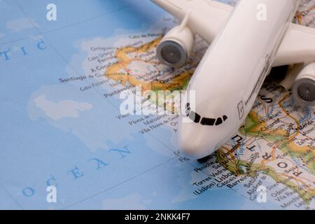 Primo piano di un aereo passeggeri in miniatura su una mappa colorata che evidenzia Lisbona, Portogallo attraverso la messa a fuoco selettiva, sfocatura dello sfondo Foto Stock