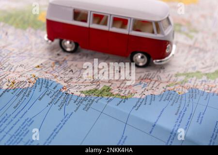 OGDEN, UTAH USA - FEBBRAIO 10 2023 Una VW rossa e bianca in miniatura su una mappa della costa californiana con focalizzazione selettiva sulla baia di Monterey Foto Stock