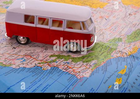 OGDEN, UTAH USA - FEBBRAIO 10 2023 Un pulmino VW rosso e bianco in miniatura su una mappa della costa centrale della California Foto Stock