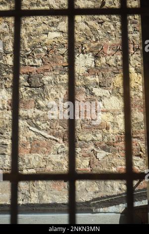 Ripresa verticale del muro visto attraverso le barre metalliche Foto Stock