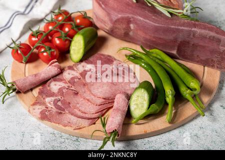 Lingua di manzo affumicata. Linguetta di vitello affumicata tagliata su tagliere in legno. Deliziosa carne affumicata. Nome locale fumo dana dil Foto Stock