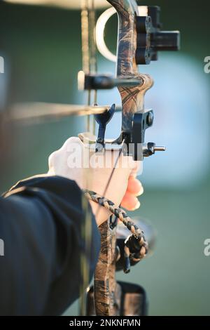 Sport arciere, mani e arco e freccia di allenamento per tiro con l'arco concorrenza, sfida atleta o pratica campo ragazza. Tiro, talento e competitivo Foto Stock