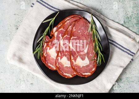 Pancetta di manzo. Fette di pastrami turchi essiccate in piatto. Prelibatezze turche tradizionali. Vista dall'alto Foto Stock