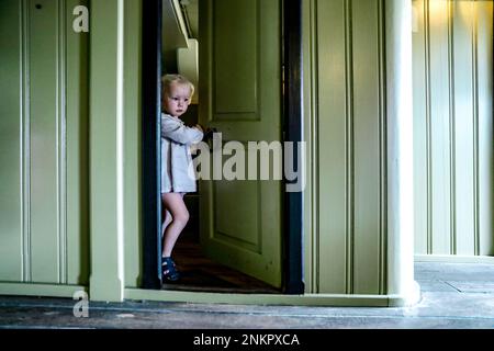 Ragazza che apre la porta e che arriva attraverso Foto Stock