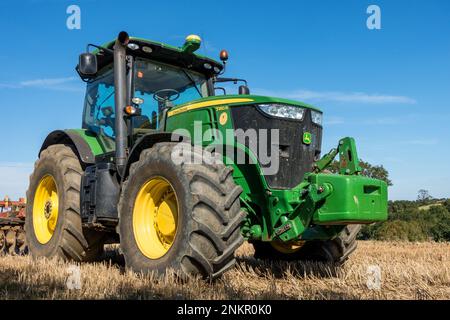 Grande trattore agricolo John Deere a 7280R file, verde brillante, con pneumatici grandi e erpice a dischi parcheggiato a Leicestershire Field, Inghilterra, Regno Unito Foto Stock